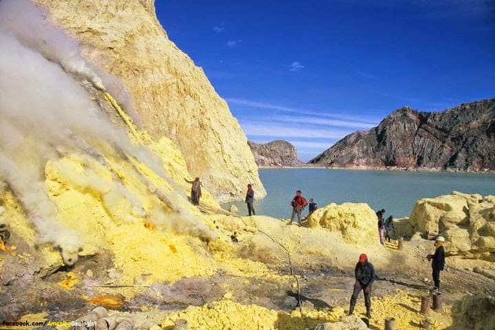 Image of a group of geologists looking at a sulphuric deposit next to a lake