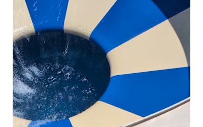Gif of Just About's Community Manager at a water park, spinning in a bowl and orbiting a hole that drops into a pool